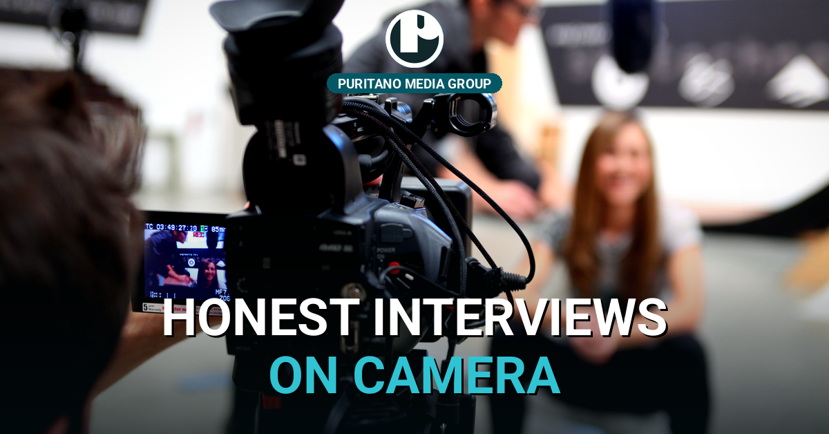 A cinema camera filming a seated interview subject on a PMG set