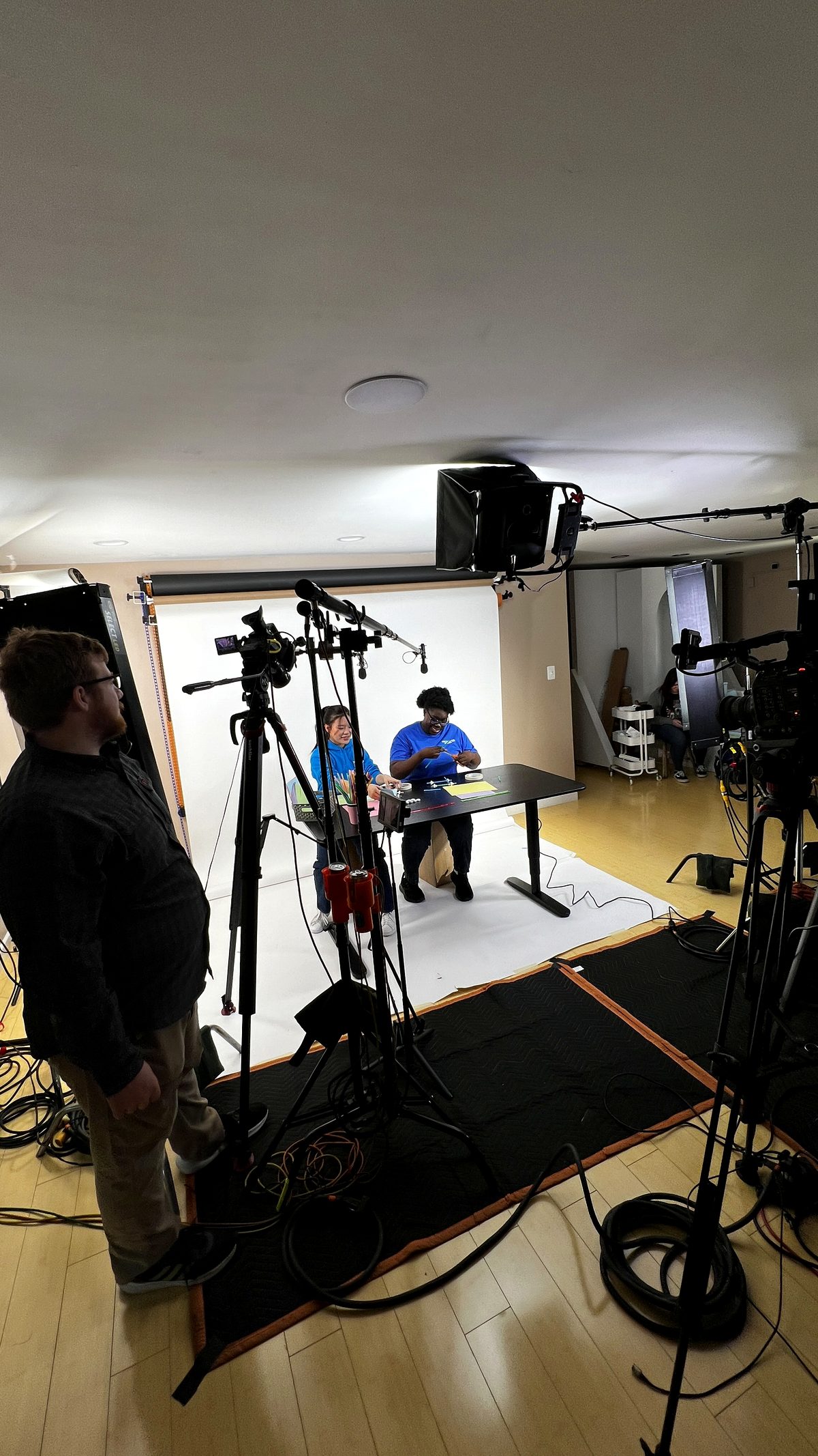 A PMG live production set with two presenters at a desk